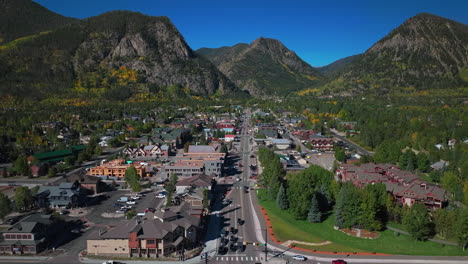 Downtown-Frisco-Colorado-aerial-cinematic-drone-traffic-Main-Street-early-yellow-fall-colors-Aspen-trees-morning-Lake-Dillon-Keystone-Breckenridge-Silverthorne-Ten-Mile-Range-blue-sky-upward-motion