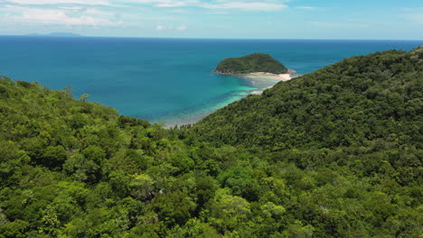 Tropical-Coastline-With-Clear-Water-Revealed-Behind-Lush-Hill,-Aerial-Ascending