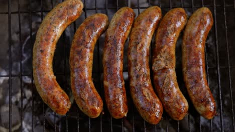 Delicious-juicy-sausages,-cooked-on-the-grill-with-a-fire.