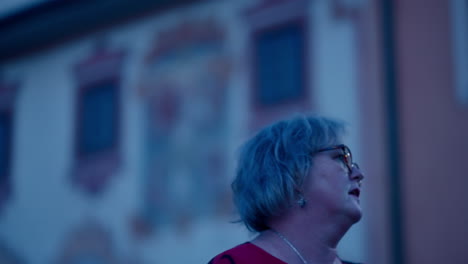 Cinematic-Close-up-of-an-older-Caucasian-Woman-looking-around-for-direction-in-an-old-historical-city-at-night-in-slow-motion