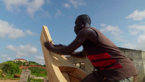 Ein-Einheimischer-Afrikanischer-Zimmermann-Glättet-Den-Bug-Eines-Holzbootes-Mit-Einem-Scheuerflugzeug