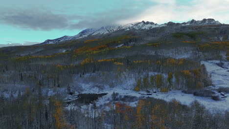 Frosted-crisp-cold-freezing-frozen-morning-shaded-Kebler-Pass-Colorado-aerial-cinematic-drone-shaded-fall-winter-season-collide-first-white-snow-red-yellow-orange-aspen-tree-forest-shaded-forward