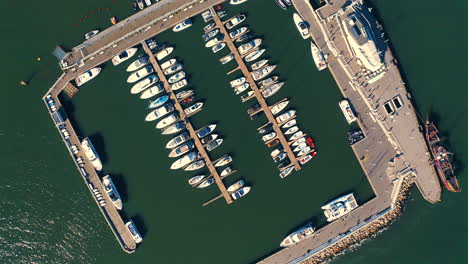 Top-view-of-drone-flying-above-the-marina-with-moored-yachts,-ships-and-motorboats-at-the-sunny-day-in-Sopot,-Poland