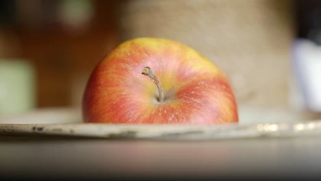 Close-up-view-of-red-apple-laying-in-a-bown-on-the-dining-table