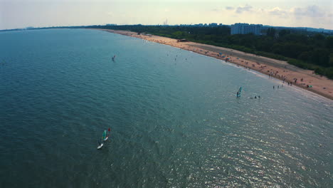 Aerial-view-of-drone-flying-above-windsurfing-near-the-beach-at-sunny-day