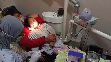 Ein-Zahnarzt-Extrahiert-Den-Zahn-Eines-Kindes,-Indonesien