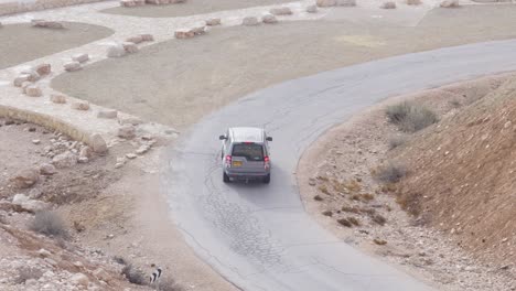 Un-Jeep,-Un-Todoterreno-Bajando-Por-Una-Carretera-Con-Curvas-En-El-Desierto