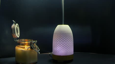 color-changing-air-humidifier-dispersing-a-line-of-mist-next-to-a-lit-flame-candle-in-a-glass-jar