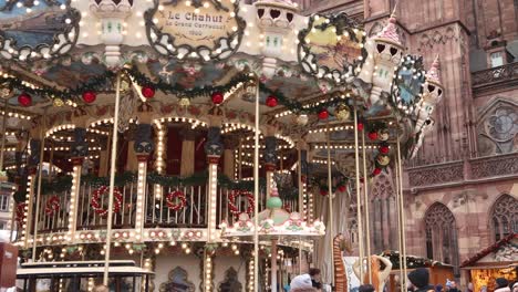 Festliches-Karussell-Dreht-Sich-Vor-Der-Straßburger-Kathedrale-Auf-Dem-Festlichen-Weihnachtsmarkt-In-Straßburg,-Frankreich,-Europa