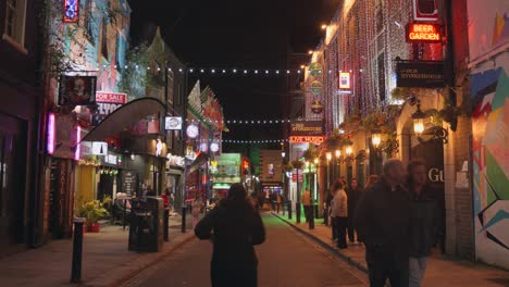 Vista-Nocturna-Del-Hermoso-Callejón-De-La-Corona-Iluminado-Con-Colores-Vivos-En-Dublín,-Irlanda