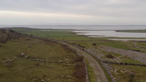 Dynamic-aerial-shot-following-a-trekking-trial-in-the-Burren,-County-Clare