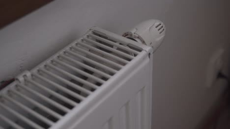 Turning-on-heating-or-radiator-thermostat,-hand-closeup,-full-power,-wasting-money
