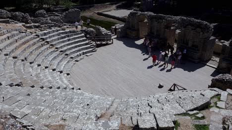 Vibrant-Crowds-of-Tourists-Explore-the-Magnificent-Amphitheater-in-Butrint,-a-Captivating-Archaeological-Site-Adventure