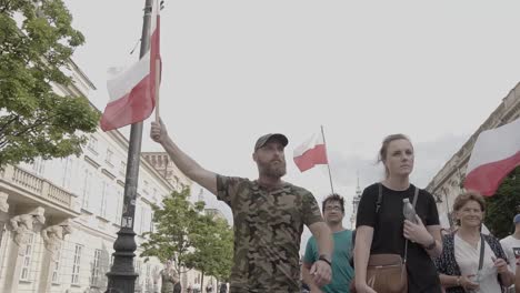 Cinematic-Shot:-Proud-Polish-Patriot-Walking-and-Holding-High-the-Polish-Flag
