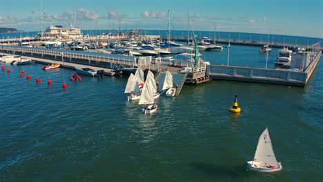 Optimist-dinghy-boats-sailong-to-the-marina-pier-at-sunny-summer-day