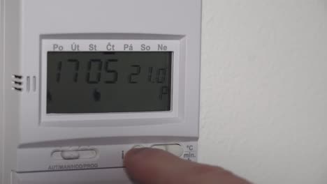 Setting-higher-heating-thermostat-temperature-on-digital-display,-closeup-view