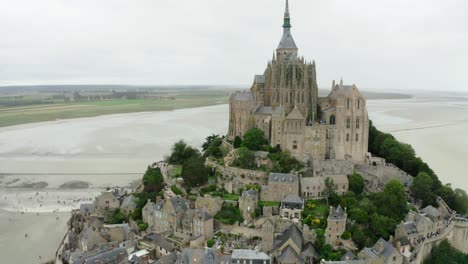 aerial-drone-view-in-mont-saint-Michel-castle-There-are-big-gardens-and-tourists-doing-photography