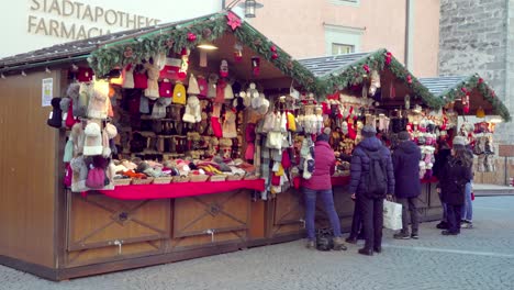Customers-in-front-of-a-stall-at-the-Christmas-market-in-Sterzing---Vipiteno,-South-Tyrol,-Italy