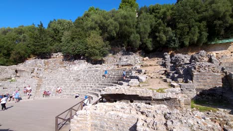 Tourists-Explore-the-Ancient-Amphitheater-of-Butrint,-Immersed-in-the-Archaeological-Wonders-of-a-Summer-Vacation-Journey