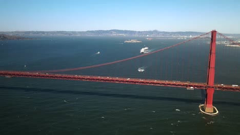 A-drone,-aerial,-cinematic-shots-of-the-San-Francisco-Golden-Gate-Bridge-with-ships-in-the-background-and-horizon-at-the-distance