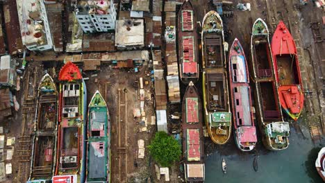 Aerial:-rusty-abandoned-cargo-ships-for-repair-at-dockyard-beside-slum-community-in-Asia