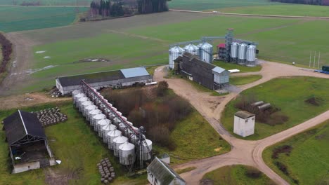 Massive-farmstead-with-modern-shining-silos,-aerial-view