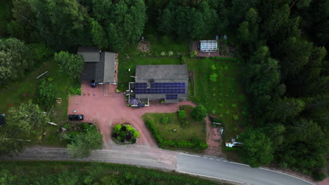 Time-lapse-drone-shot-of-clouds-moving-over-a-family-house-powered-with-solar-cells