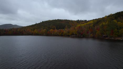 Fall-Colors-Surrounding-Lake-On-A-Cloudy-Day-In-New-England,-USA