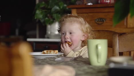 Toddler-eating-a-waffle-in-the-vintage-dining-room-of-grandmother,-sitting-at-the-table