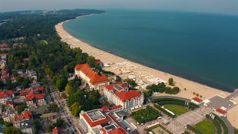 Aerial-view-of-drone-flying-above-Sopot-city-towards-the-Monciak-pier-with-baltic-sea-in-the-background