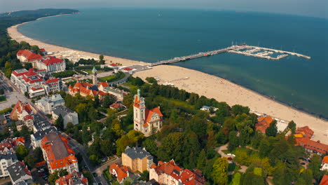 Drone-flying-above-Sopot-city-towards-Monciak-pier-at-sunny-day