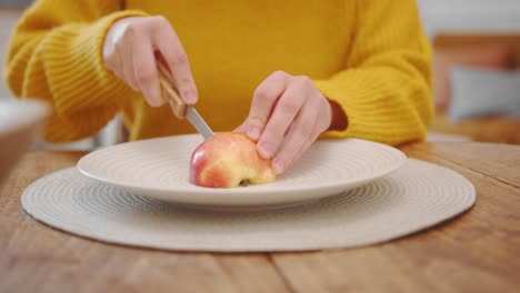 Junge-Gesunde-Frau-Schneidet-Frischen-Apfel-In-Zwei-Hälften,-Vorderansicht