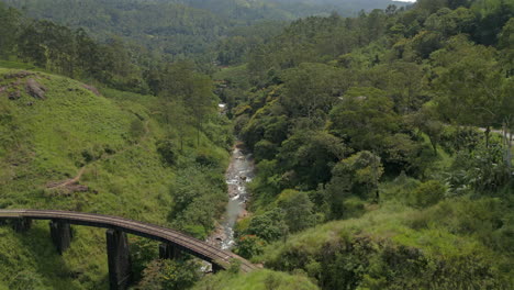 Absteigende-Luftaufnahme-Der-Demodara-Eisenbrücke-Mit-Blick-Auf-Das-Tal-In-Sri-Lanka-An-Einem-Sonnigen-Tag