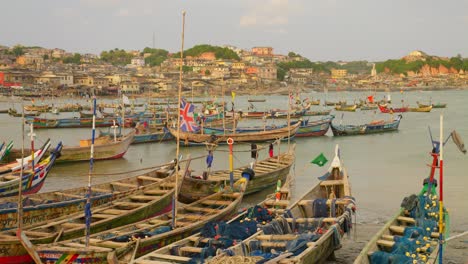 Wooden-fishing-boats-with-flags-in-sea-harbor-at-Cape-Coast-in-Ghana