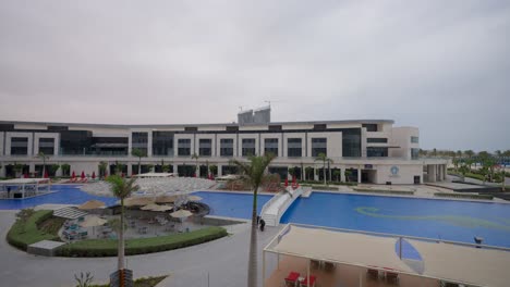 Ein-Blick-Von-Einem-Hohen-Gebäude-Eines-Hotels-In-El-Alamein-Mit-Blick-Auf-Das-Meer-Und-Die-Pools,-Totalaufnahme,-Schwenk