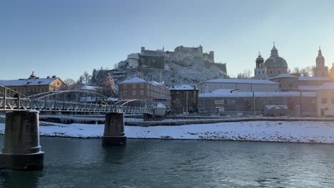 Salzburger-Blick-Auf-Den-Burgfluss-Und-Die-Mit-Weißem-Schnee-Bedeckte-Brücke-An-Einem-Sonnigen-Tag