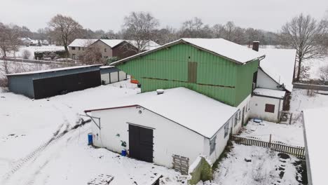 Aerial-view-of-a-snowy-farm-with-horses-in-northern-germany
