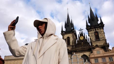Female-tourist-make-video-call-near-Church-of-our-lady-before-tyn,-Prague