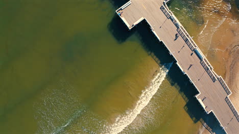 Aerial-view-of-Pier-with-sea-waves-coming-to-the-beach
