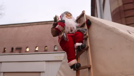 Spielzeug-Weihnachtsmann-Klettert-Auf-Einer-Leiter-Auf-Das-Dach-Eines-Gebäudes-Auf-Dem-Festlichen-Weihnachtsmarkt-In-Straßburg,-Frankreich,-Europa