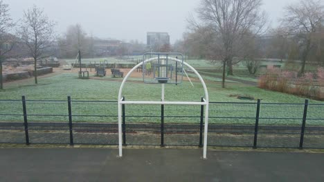Dolly-out-of-metal-hoop-of-urban-basketball-court-on-a-cold-and-misty-morning