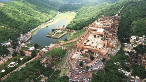 Luftaufnahme-Des-Historischen-Schlosses-Auf-Einem-Hügel-Mit-Grüner-Vegetation-Und-Seen-In-Indien,-Rajasthan