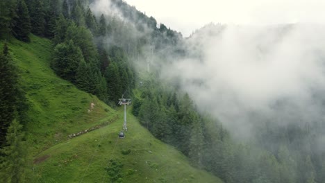 Rope-way-leading-up-a-steep-mountain-on-a-very-cloudy-day-in-the-Alps-in-Lofer,-Austria
