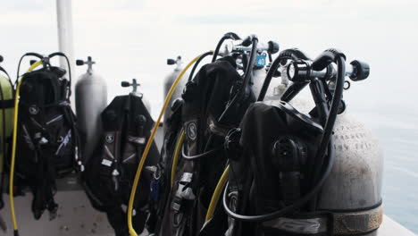 Scuba-tanks-stand-prepped-for-adventure-against-a-backdrop-of-a-cloudy-ocean-sky