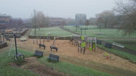 Aerial-of-beautiful-green-park-in-a-suburban-neighborhood-on-a-cold-and-misty-morning