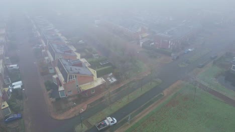 Luftaufnahme-Eines-Parkplatzes-In-Einem-Nebelbedeckten-Vorstadtviertel