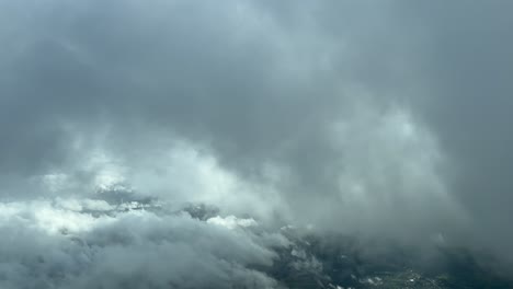 Escena-De-Nubes-Tomada-Desde-La-Cabina-De-Un-Avión-Vista-Por-Los-Pilotos-Mientras-Volaban-A-Través-De-Algunas-Nubes-Esponjosas-Con-Un-Frío-Cielo-Invernal
