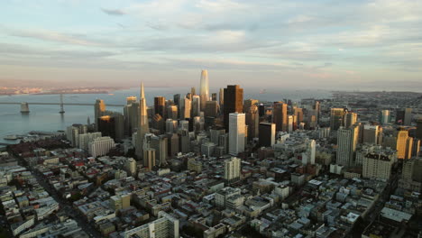 Aerial-tilt-shot-rising-in-front-of-the-sunlit-skyline-of-San-Francisco,-CA,-USA