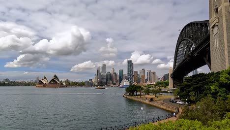 Sydney-Harbour-Bridge,-Schwenk-Nach-Links,-Mit-Opernhaus-Und-Skyline-Der-Stadt-Im-Hintergrund