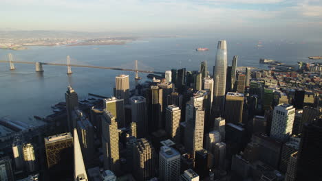 Aerial-pan-shot-of-downtown-San-Francisco-and-the-Oakland-Bay-Bridge,-in-sunny-USA